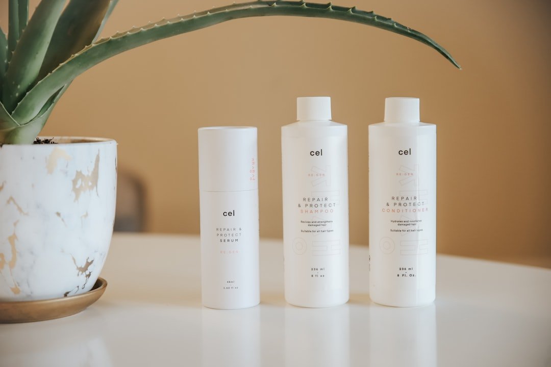 A variety of hair care products arranged aesthetically on a bathroom counter, including shampoos, conditioners, and styling tools.