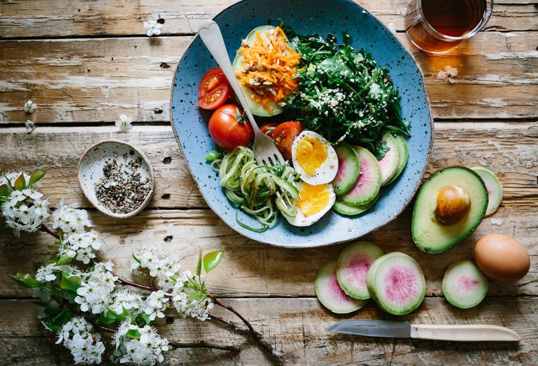 A vibrant assortment of healthy foods including fruits, vegetables, and protein sources, with a glass of water in the background, symbolizing nutrition and hydration.