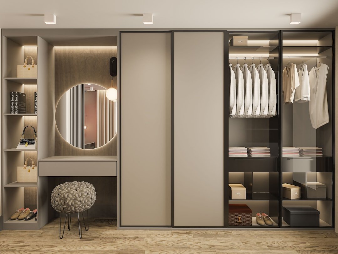 A neatly organized closet featuring classic clothing items like a tailored blazer, white shirt, and versatile trousers, showcasing a minimalist approach to fashion.