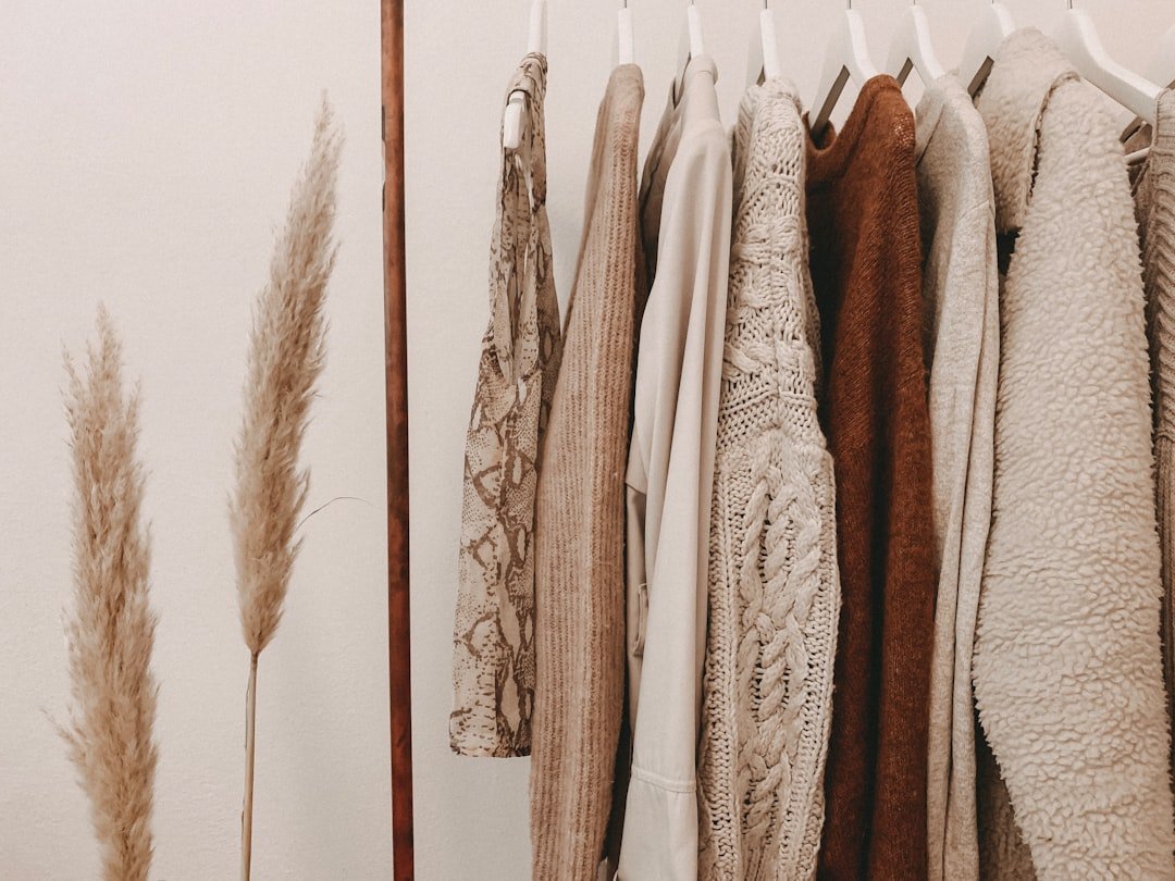 A stylish and organized wardrobe showcasing a variety of classic clothing pieces, emphasizing quality and cohesion in colors and styles.