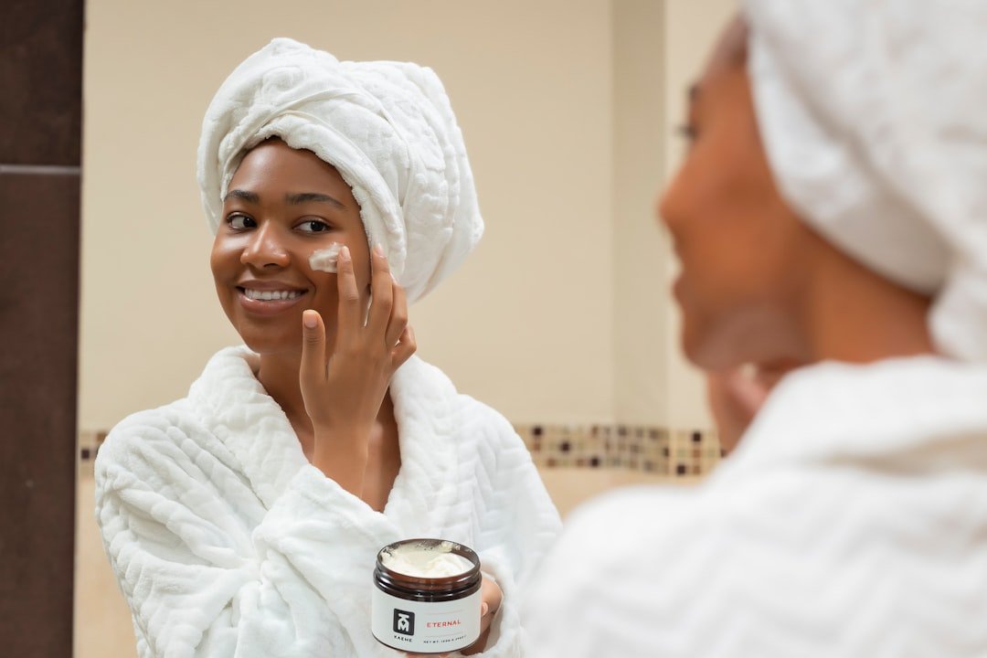 A serene image of a person applying moisturizer to their skin, surrounded by seasonal elements like autumn leaves, winter snowflakes, spring flowers, and summer sunshine.