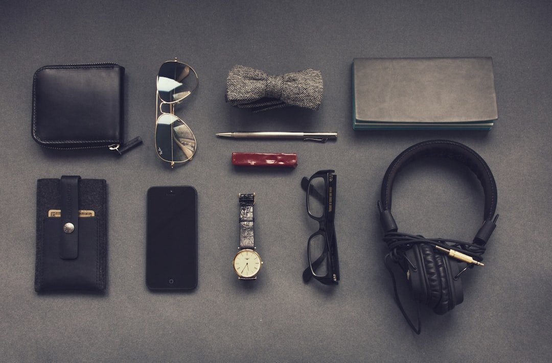A collection of stylish accessories including a watch, necklace, and handbag arranged aesthetically on a soft fabric background.