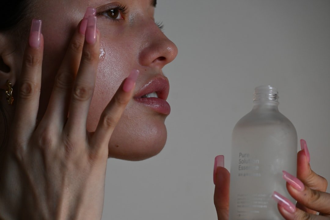 A close-up of hands applying moisturizer on a smooth skin surface, showcasing a creamy texture.